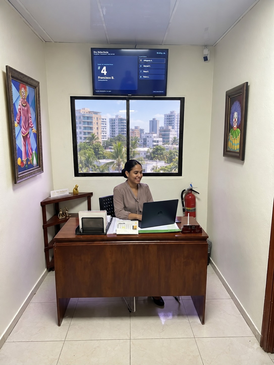 Recepción de consultorio con computadora y pantalla de turnos
